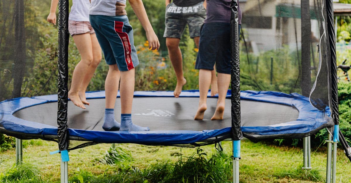 Children jumping together on an outdoor backyard trampoline.